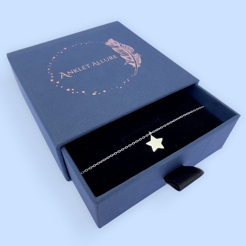 A17-Anklet-(2) Shiny bright anklet with solid silver star charm, presented in a blue jewellery box with Anklet Allure written on the top in rose gold.