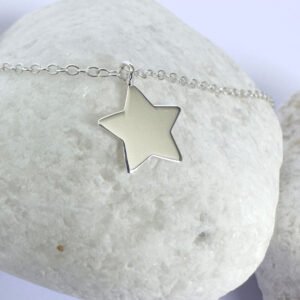 Close up of shiny bright anklet with solid silver star charm.