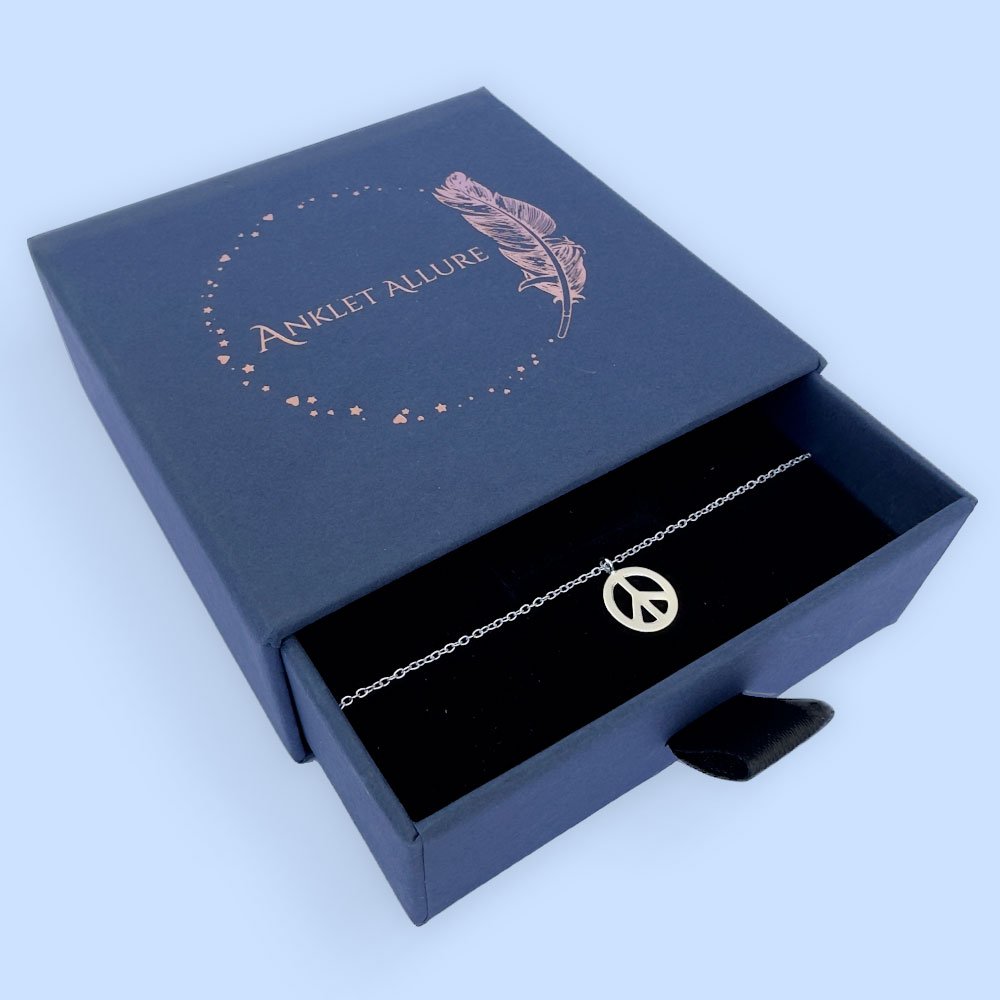 A19-Anklet-(2) Beautiful peace symbol charm on a silver anklet, presented in a blue jewellery box with Anklet Allure written on the top in rose gold.