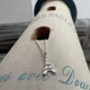 Eiffel Tower charm on a silver ankle bracelet laying on a lighthouse decoration.