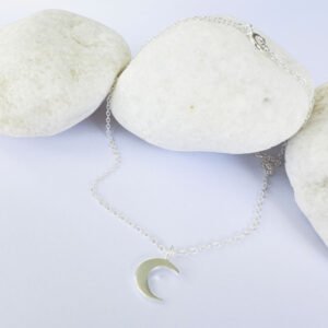 Feminine silver anklet with a crescent moon charm.