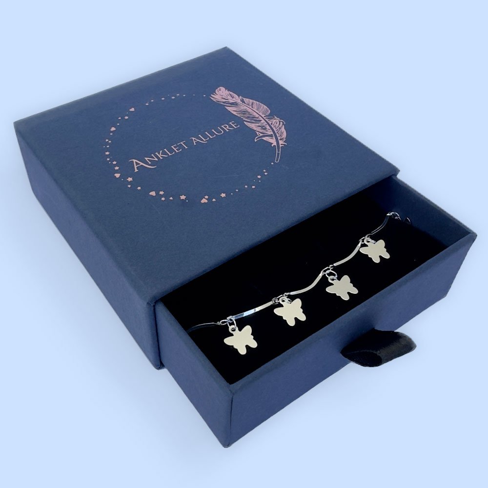 B3-Anklet-box Stiff silver ankle chain with solid butterfly charms in a blue jewellery box.