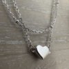Simple sterling silver heart charm on a plain silver anklet.