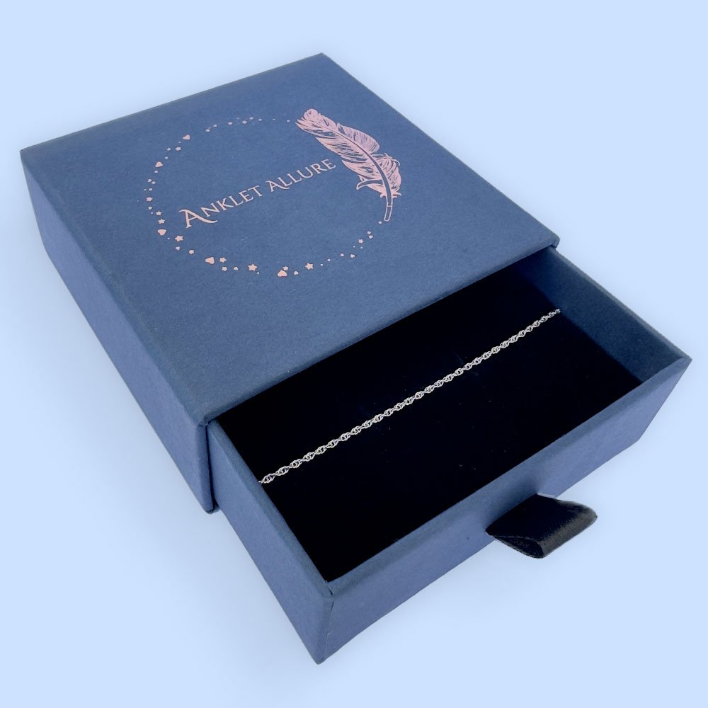 C6-Anklet-box Plain silver ankle bracelet presented in a dark blue Anklet Allure gift box.
