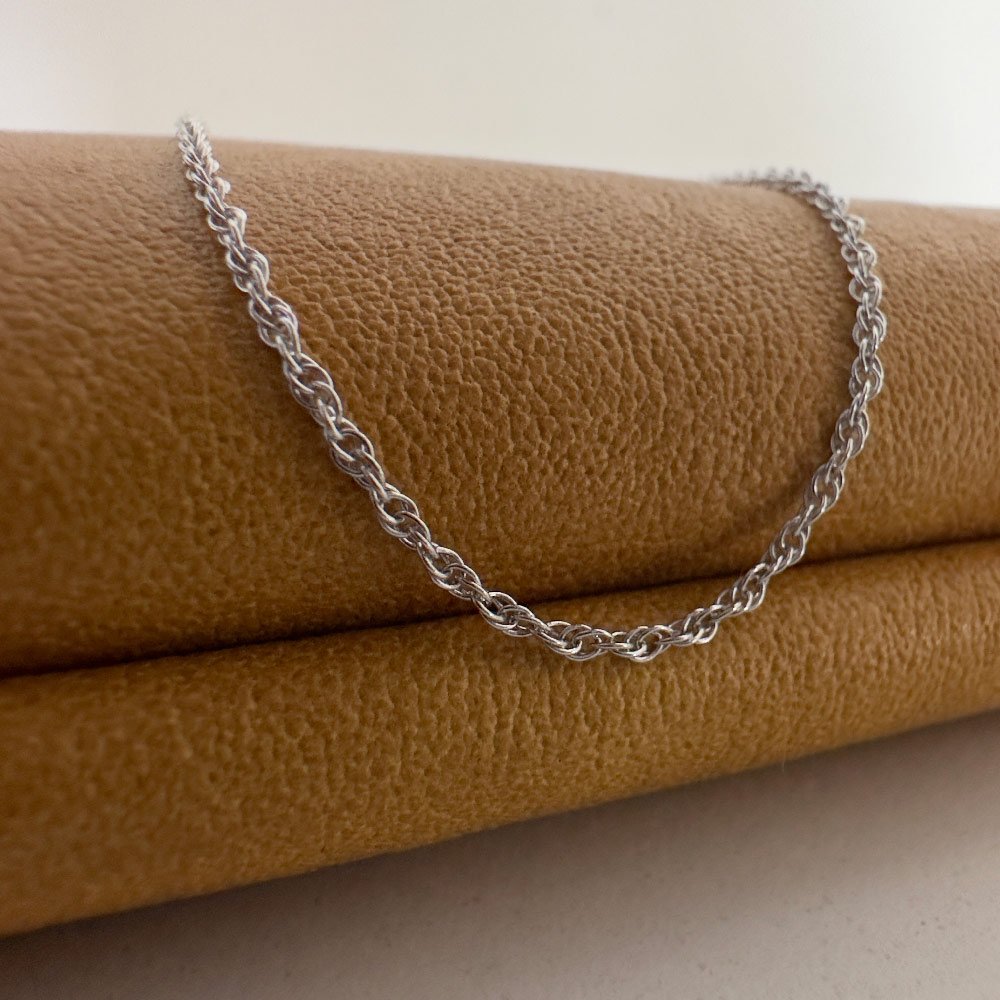 C6-Simply-Chic-Anklet-Silver-main-image Close up of a simple and chic silver chain hung over a mustard purse.
