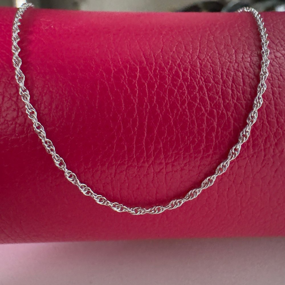 C6-Simply-Chic-Anklet-Silver Chic simple silver anklet draped over a red purse.