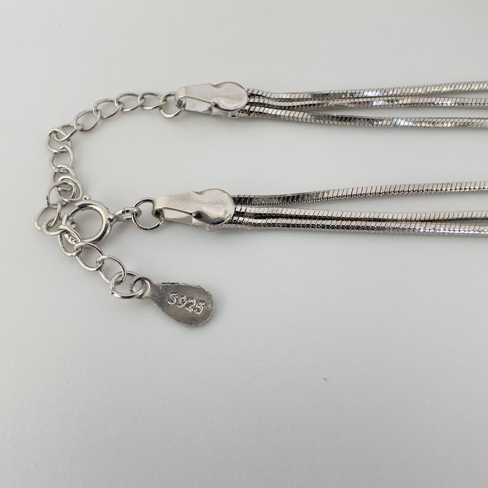 D1-Anklet-(3) Close up of triple chain silver anklet with 925 sterling silver stamp.