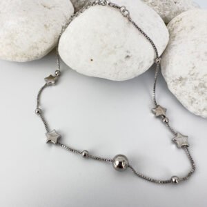 Silver anklet with solid star and ball charms on white rocks.
