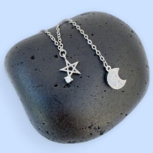 Ankle bracelet with a five pointed star and a crescent moon, both diamond encrusted, displayed on a black rock.