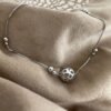 Sterling Silver anklet with a globe like ball as the main feature and smaller balls around the chain in pairs, one bigger than the other.