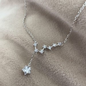 Seven smaller cubic zirconia gems linked together in a pattern similar to the big dipper star formation, with a larger gemstone as the main feature hanging lower from the silver ankle bracelet.