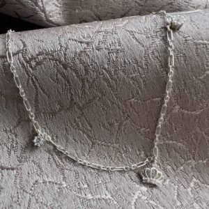 Regal sterling silver paperclip style ankle chain with two cubic zirconia gems on each side of the chain and a crown charm with cubic zirconia detail in the middle.