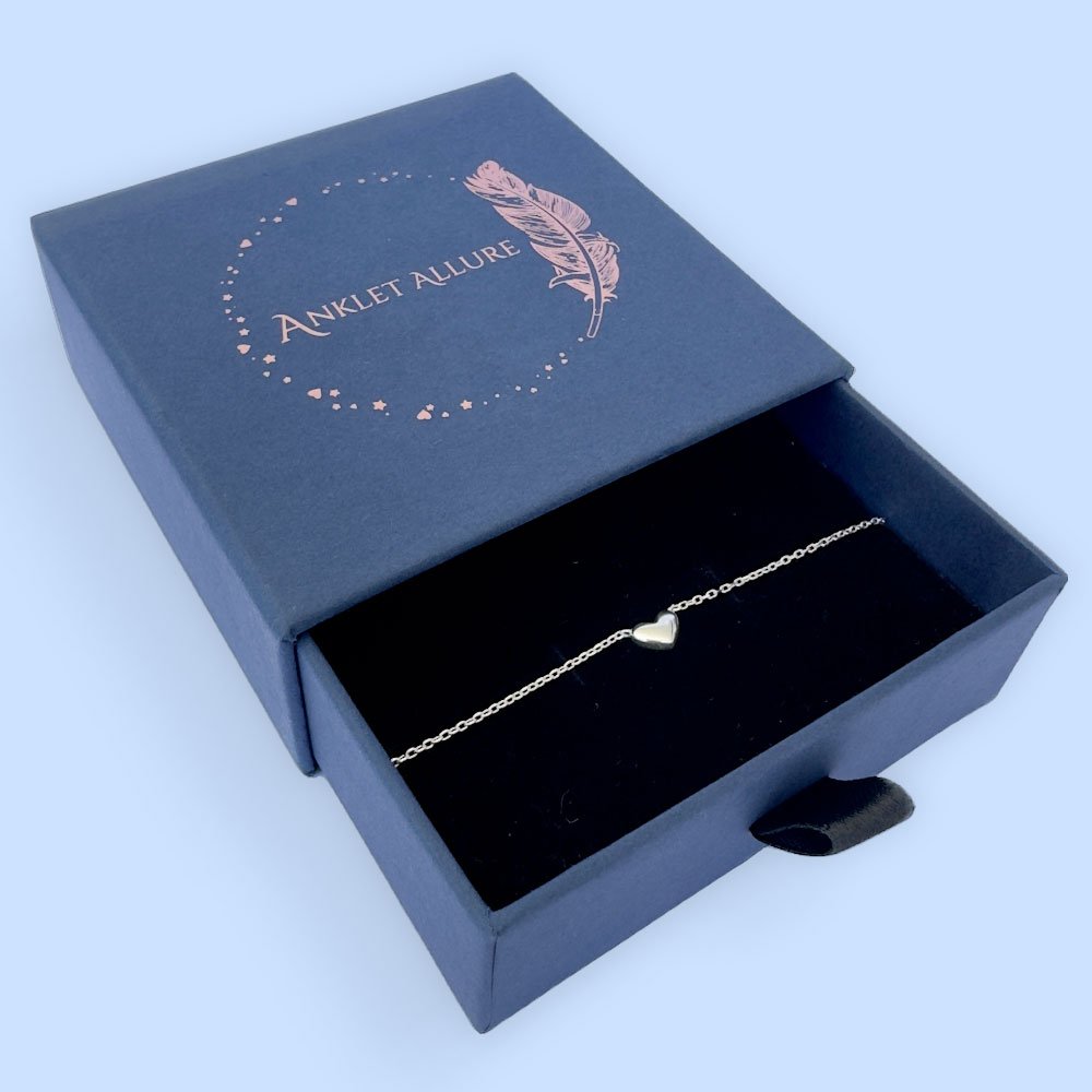 E4-Anklet-box Stunning silver anklet with a cute solid silver heart charm in a blue Anklet Allure jewellery box.