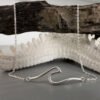Beach Chic anklet of a shiny silver rolling wave draped over some driftwood.