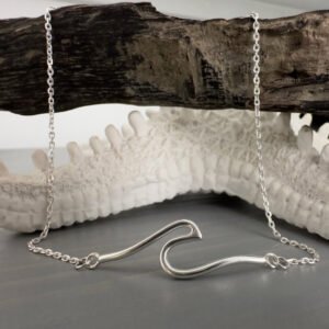 Beach Chic anklet of a shiny silver rolling wave draped over some driftwood.