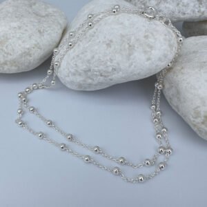 Woman's anklet in silver with small balls all the way around on white rocks.